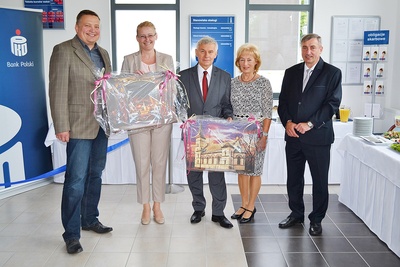 Nie zabrakło także gratulacji i ciepłych słów naszego włodarza, który życzył owocnej działalności i wielu zadowolonych klientów, przekazując jednocześnie szefowej banku Annie Wężyk oraz właścicielowi budynku p. Joachimowi Palm obrazy przedstawiające Zabytkowy Most i Kościół Ewangelicki w Ozimku.
