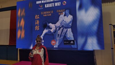 Natalia z trofeum na tle baneru z turnieju