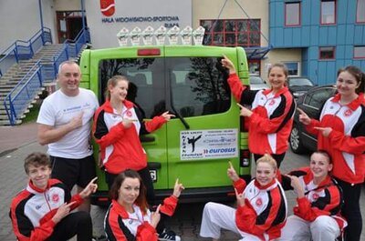 Nidan z autem sponsora w tle